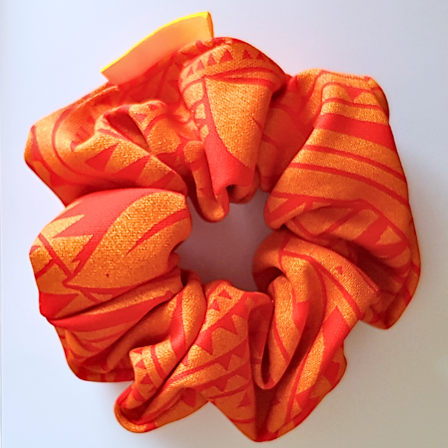 Pasifika hair scrunchies. made from cotton. pacific island pattered fabric. sizes available small, medium, large and extra large. this style is red orange